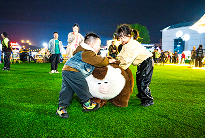 1775092409792011290.jpg 大会现场,孩子们与“小老费”机器狗一起玩耍。.jpg